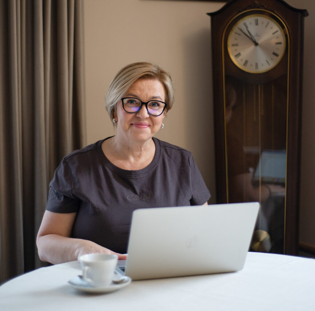 Agnieszka Rajs-Glazar ekspert w terapii dzieci w spektrum autyzmu z komputerem na tle starego zegara